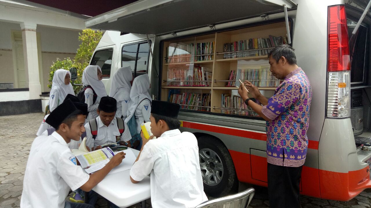 Asik. Pelajar SMA di Sumenep menikmatai buku-buku yang disediakan Mobil KaCa UMM. وتواصل